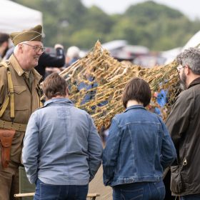 Visitors speaking to a member of the vintage village at the USA stand.
The RAF Cosford Airshow, Sunday 9th June 2024 is the primary airshow of the Royal Air Force attracting in excess of 55,000 visitors it is one of the biggest events in the West Midlands. This Years theme was ‘Take Flight’ with displays, events and activities aiming to drive potential new recruits to kickstart their interest of a career in the RAF and develop an understanding of what the British Military, Allied Forces and Sister Services do for the defence of the United Kingdom. Visitors are able to get close to the cutting edge of technology with RAF Aircraft and unique attractions across the show ground and immerse themselves in a thrilling action-packed flying display programme.
The RAF Cosford Airshow is an excellent way for the Ministry of Defence to engage with the public and showcase the Royal Air Force’s capabilities and to celebrate the service’s history while looking ahead to the next generation of people and technology.
RAF Cosford in Shropshire is a major part of the Defence College of Technical Training (DCTT). It is at the centre of the RAF’s mission to deliver flexible, affordable, modern and effective technical training that meets the needs of the UK’s Armed Forces now and into the future. RAF Apprenticeships delivered at RAF Cosford were recently recognised as ‘Outstanding’ by Ofsted. RAF Cosford is also home to the popular RAF Museum and the world-renowned Cosford Airshow.
