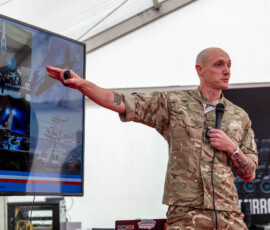 Pictured is Sgt Phil Dye giving his presentation at the Cosford Air Show 2026.
RAF Cosford Air Show 2026, themed “Engineering the Future,” took place on Sunday 14 June 2026, offering a one‑day, family‑friendly aviation spectacle with headline flying displays (including the Red Arrows), a mix of modern fast jets, historic warbirds and international participants, extensive static exhibits and new museum acquisitions, plus interactive STEM zones, a vintage village and trade stalls; gates opened at 08:00, organisers warned the event sold out in advance with no on‑the‑day sales, Cosford station and nearby roads were extremely busy with road closures in place, and attendees were advised to bring printed or screenshot tickets, ear protection for children, folding chairs or picnic blankets, and cash, while independent broadcasters streamed the flying display for those who couldn’t attend and organisers published late substitutions to the flying programme where operational issues required changes.
Photo captured AS1 Samuel Marcham, 14th June 2026.